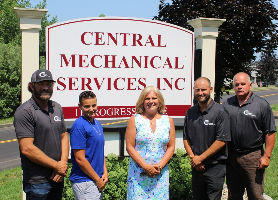 Central Mechanical employees in front of company sign